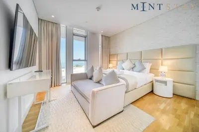 a bedroom with a king sized bed and a couch at Bluewaters Residences 5, Bluewaters Island - Mint Stay in Dubai