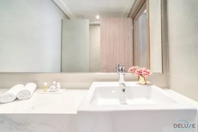 a white bathroom with a sink and a mirror at Decent 1BR at Azizi Riviera 17, Al Merkadh by Deluxe Holiday Homes in Dubai