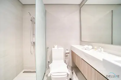 a bathroom with a toilet and a sink and a mirror at Decent 1BR at Azizi Riviera 17, Al Merkadh by Deluxe Holiday Homes in Dubai