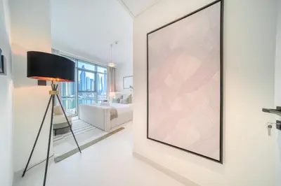 a large picture on a wall in a room with a lamp at Seaside Splendor: Luxe Retreat at Emaar Beachfront in Dubai