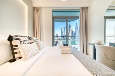 a bedroom with a large window with a view of the city at Seaside Splendor: Luxe Retreat at Emaar Beachfront in Dubai