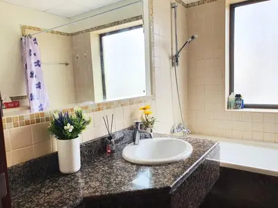 a bathroom counter with a sink and a bath tub at JBR Retreat: Stylish Views in Dubai