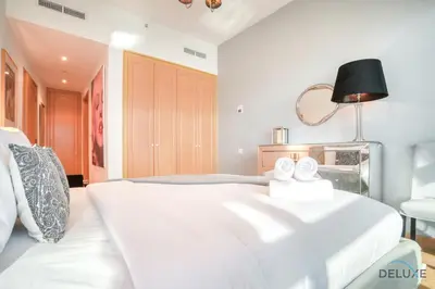 a bedroom with a large white bed and a lamp at Contemporary 1BR at Marina Terrace Tower Dubai Marina by Deluxe Holiday Homes in Dubai