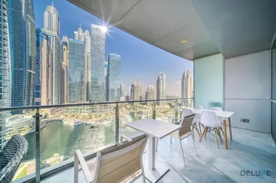 a balcony with tables and chairs and a view of the city at Contemporary 1BR at Marina Terrace Tower Dubai Marina by Deluxe Holiday Homes in Dubai