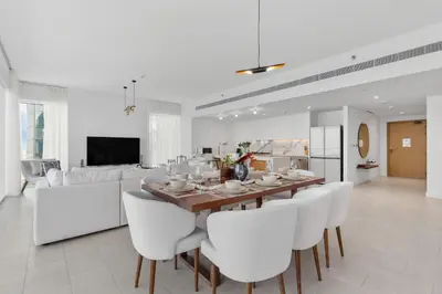 a dining room with a table and white chairs at Maison Privee - Upscale Apt w/ Open Sea and Bluewaters Vws in JBR in Dubai