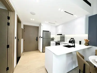 a kitchen with white cabinets and a white counter top at Trophy - Stardust Sanctum Suites w Pool view in Heart of JVC in Dubai