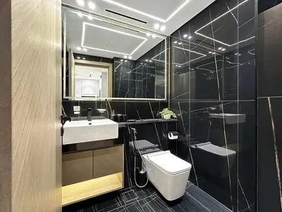 a bathroom with a toilet and a sink and a mirror at Trophy - Stardust Sanctum Suites w Pool view in Heart of JVC in Dubai