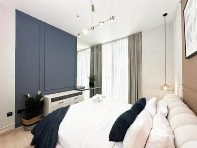 a bedroom with a large white bed and a couch at Trophy - Stardust Sanctum Suites w Pool view in Heart of JVC in Dubai