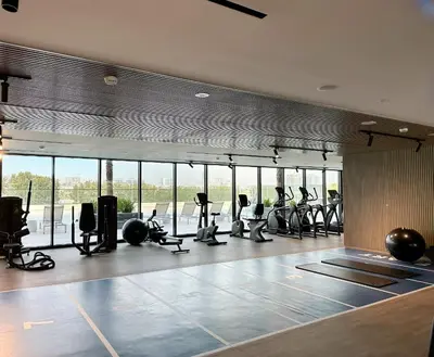 a gym with treadmills and elliptical machines at Trophy - Stardust Sanctum Suites w Pool view in Heart of JVC in Dubai