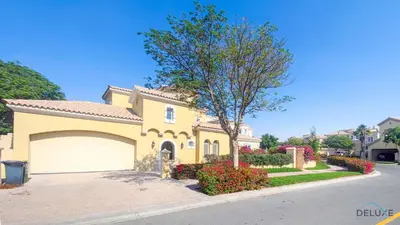 a yellow house with a garage on a street at Luxury 3BR Villa with Assistant Room at Alvorada 4 Arabian Ranches by Deluxe Holiday Homes in Dubai