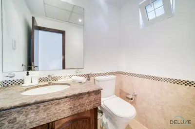 a bathroom with a toilet and a sink and a mirror at Luxury 3BR Villa with Assistant Room at Alvorada 4 Arabian Ranches by Deluxe Holiday Homes in Dubai