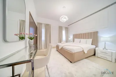 a white bedroom with a bed and a glass table at Luxury 3BR Villa with Assistant Room at Alvorada 4 Arabian Ranches by Deluxe Holiday Homes in Dubai