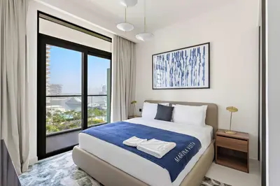 a bedroom with a bed and a large window at Silkhaus Beach Vibes with Harbor View & Private Beach in Dubai