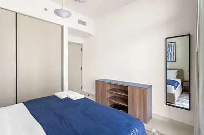 a bedroom with a blue bed and a mirror at Silkhaus Beach Vibes with Harbor View & Private Beach in Dubai