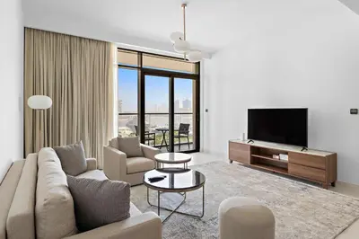 a living room with a couch and a tv at Silkhaus Beach Vibes with Harbor View & Private Beach in Dubai