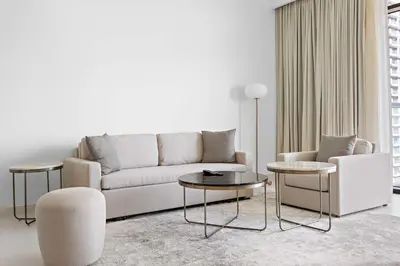 a living room with a couch and two tables at Silkhaus Beach Vibes with Harbor View & Private Beach in Dubai