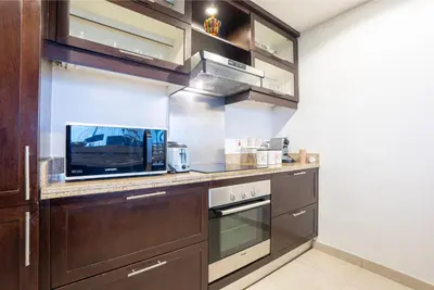 a kitchen with wooden cabinets and a counter top at Luxury 2BR Superior Apartment with Full Burj Khalifa and Dubai Mall Dancing Fountain View, Royal Tiffany in Dubai