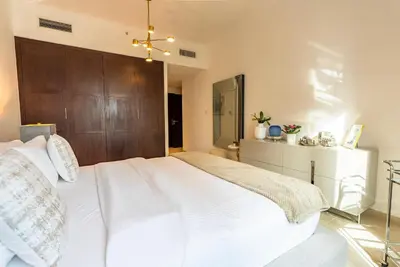 a bedroom with a large white bed with a wooden headboard at Luxury 2BR Superior Apartment with Full Burj Khalifa and Dubai Mall Dancing Fountain View, Royal Tiffany in Dubai