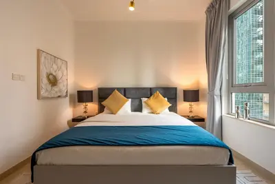 a bedroom with a large bed and two windows at Luxury 2BR Superior Apartment with Full Burj Khalifa and Dubai Mall Dancing Fountain View, Royal Tiffany in Dubai