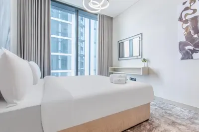 a white bedroom with a large bed and large windows at STAY BY LATINEM Luxury 2BR Holiday Home W1813 near Burj Khalifa in Dubai