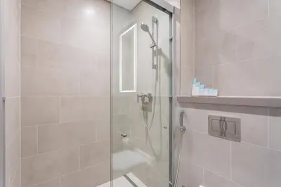 a shower with a glass door in a bathroom at STAY BY LATINEM Luxury 2BR Holiday Home W1813 near Burj Khalifa in Dubai