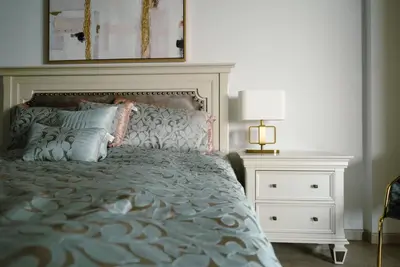 a bedroom with a bed and a night stand with a lamp at Palm Apt. with Burj al arab view in Dubai