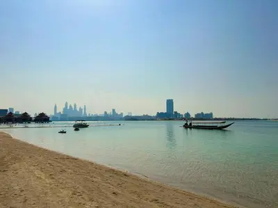 a beach with boats in the water near a city at Palm Apt. with Burj al arab view in Dubai
