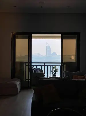 a living room with couches and a view of the ocean at Palm Apt. with Burj al arab view in Dubai