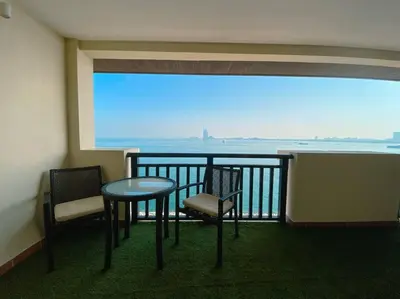 a balcony with a table and chairs and a view of the ocean at Palm Apt. with Burj al arab view in Dubai