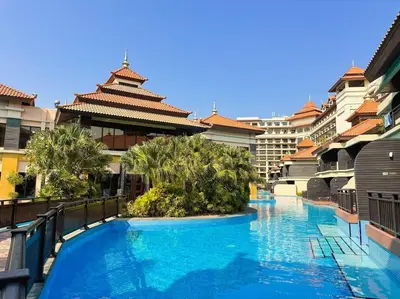 a swimming pool in a resort with trees and buildings at Palm Apt. with Burj al arab view in Dubai