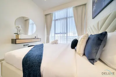 a bedroom with a white bed with a large window at Sizeable 1BR at Azizi Riviera 35, Al Merkadh by Deluxe Holiday Homes in Dubai