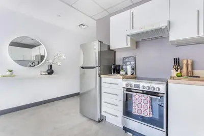 a kitchen with white cabinets and a stainless steel refrigerator at Frank Porter - Marina Views Tower B in Dubai