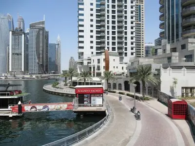 a boat on a river in a city with tall buildings at Frank Porter - Marina Views Tower B in Dubai