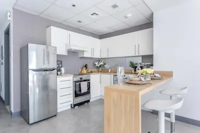 a kitchen with white cabinets and a stainless steel refrigerator at Frank Porter - Marina Views Tower B in Dubai