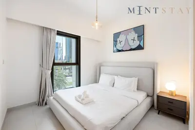a white bedroom with a bed and a window at Burj Crown , Downtown Dubai - Mint Stay in Dubai