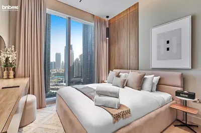 a bedroom with a large bed and a large window at bnbmehomes - Forte in Dubai