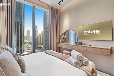 a bedroom with a bed and a flat screen tv at bnbmehomes - Forte in Dubai