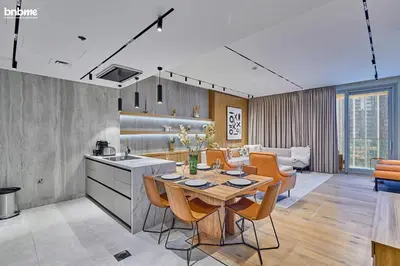 a kitchen and living room with a table and chairs at bnbmehomes - Forte in Dubai