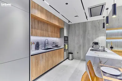 a kitchen with wooden cabinets and a counter top at bnbmehomes - Forte in Dubai