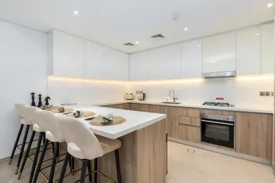 a kitchen with white cabinets and bar stools at LIV Residence - Luxurious 2BR - Dubai Marina View - Marina Walk in Dubai