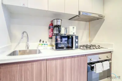 a kitchen with a sink and a microwave at Exclusive Deal, Chic 1BR at a Special Price by Deluxe Holiday Homes in Dubai