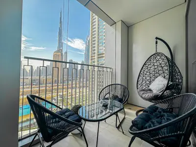 a balcony with chairs and a table and a window at Amazing Burj Khalifa Views with Direct Dubai Mall Access, 2BR Apartment in Downtown Dubai in Dubai