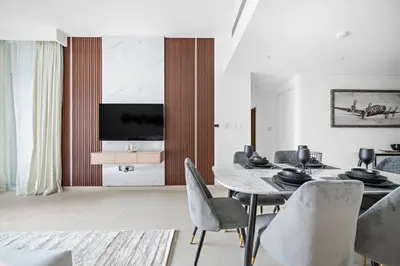 a dining room with a table and chairs and a television at Amazing Burj Khalifa Views with Direct Dubai Mall Access, 2BR Apartment in Downtown Dubai in Dubai