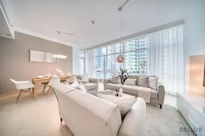 a living room with white furniture and a desk and windows at Colossal 2BR at MAG 218 Dubai Marina by Deluxe Holiday Homes in Dubai