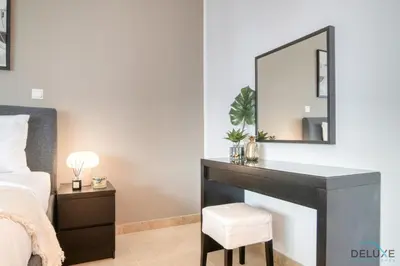 a bedroom with a vanity with a mirror and a chair at Colossal 2BR at MAG 218 Dubai Marina by Deluxe Holiday Homes in Dubai