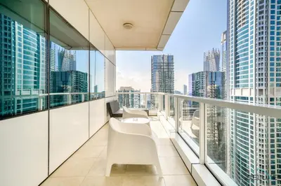 a balcony with white chairs and a view of the city at Colossal 2BR at MAG 218 Dubai Marina by Deluxe Holiday Homes in Dubai
