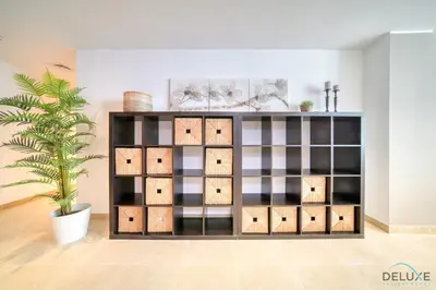 a shelf with boxes and a plant in a room at Colossal 2BR at MAG 218 Dubai Marina by Deluxe Holiday Homes in Dubai