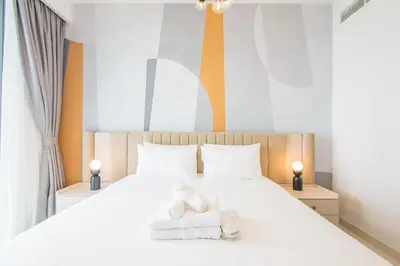 a bedroom with a white bed with towels on it at Marvelous Apartment in Beachfront Private Beach in Dubai