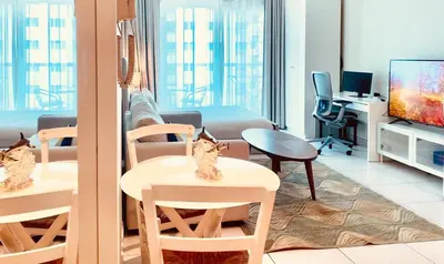 a living room with a couch and a table and a tv at Full sea view with balcony - Studio Apartment - 10 min to JBR - in Dubai