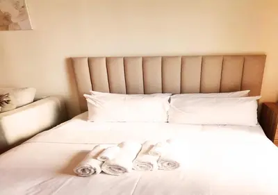 a bed with two pairs of slippers on it at Full sea view with balcony - Studio Apartment - 10 min to JBR - in Dubai